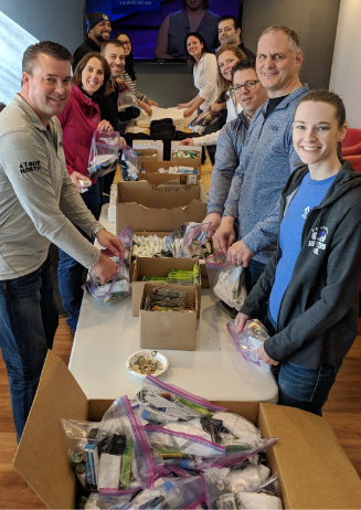 Photo of RBA employees packing homeless care bags Photo of RBA employees packing homeless care bags