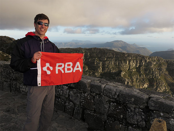 Image of RBA male caucasian employee holding RBA flag