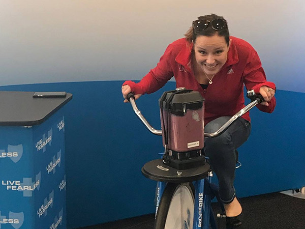 Photo of RBA female employee riding stationary bike