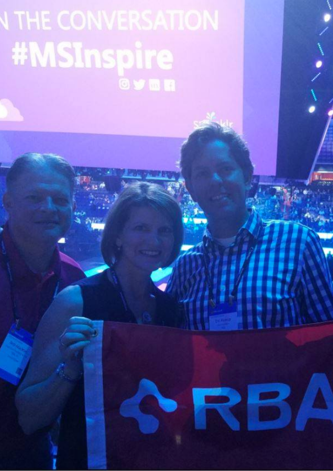 Photo of RBA employees at a conference holding RBA flag